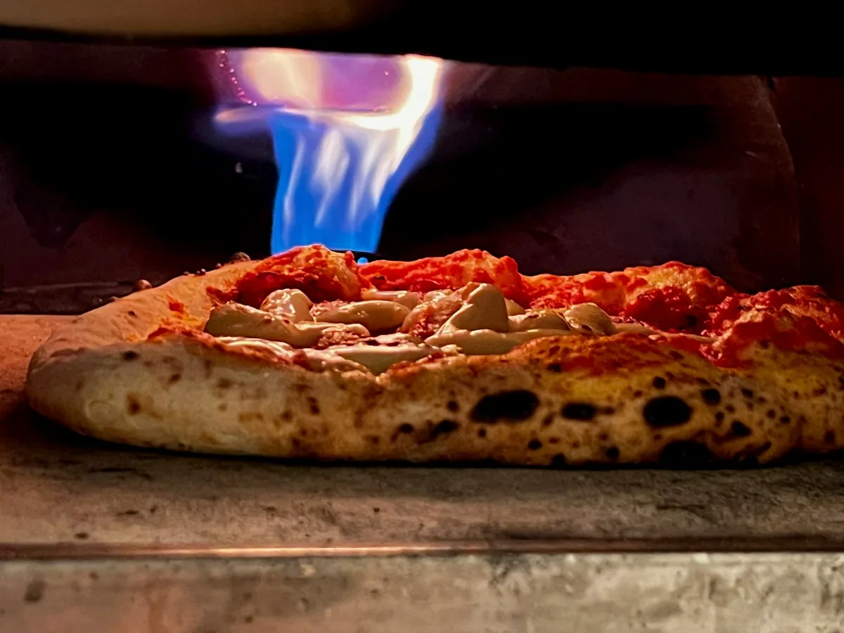Pizza baking on a hot surface inside a pizza oven